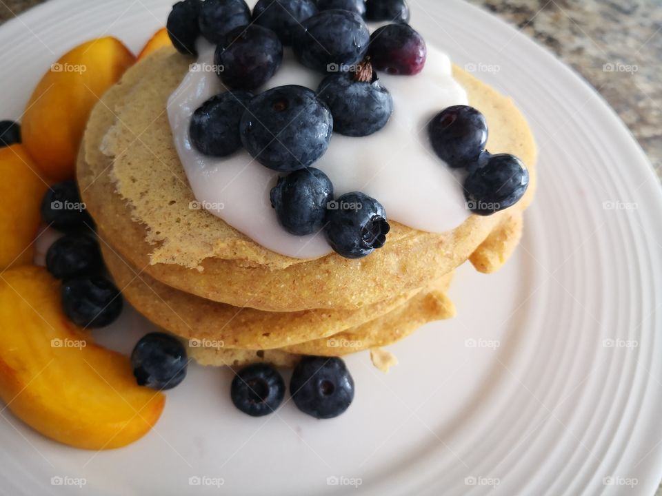 Protien packed pancakes with vegan yogurt blueberries and peaches