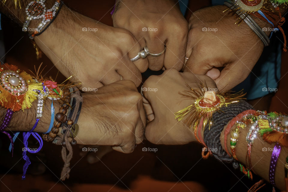 Close up hand fist of human boys friends waring friendship band on arms. Teamwork confident togetherness positivity expression celebration and spirit gesture. Team unity united hands together concept