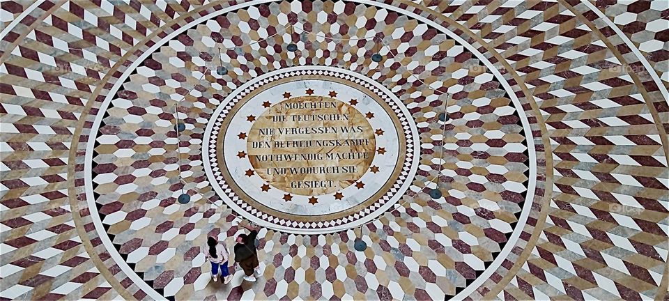 The inscription on the mosaic floor of “Liberation Hall” by “Kelheim”, Bavaria reads: “May we never forget what made the Liberation Wars necessary and Germany’s victory” referring to the 1813 - 1815 war against “Napoleon”. 2024. Hypnotic Productions