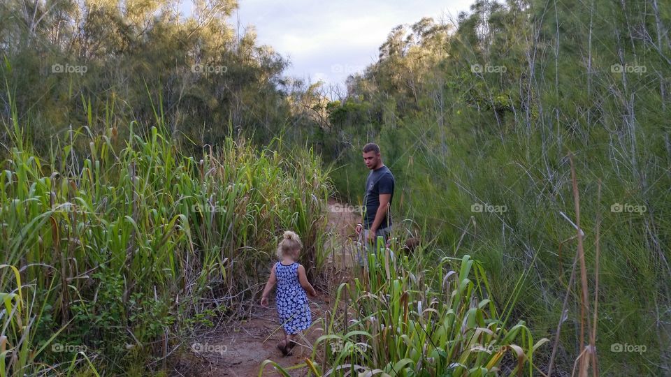 Father and daughter walking in field