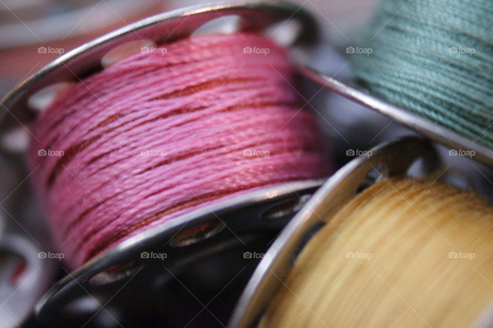 Hot pink, yellow and turquoise thread bobbins