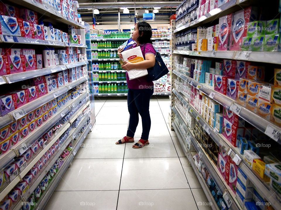 a woman inside a grocery store choosing bath soap from a shelf