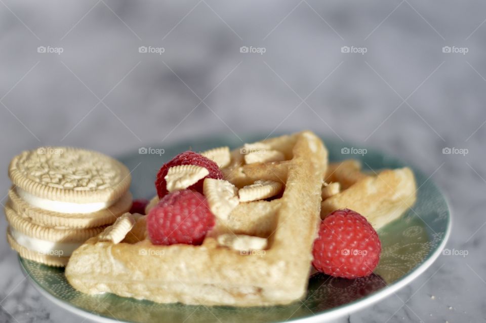 Golden double stuff Oreo cookies and a waffle with raspberries 