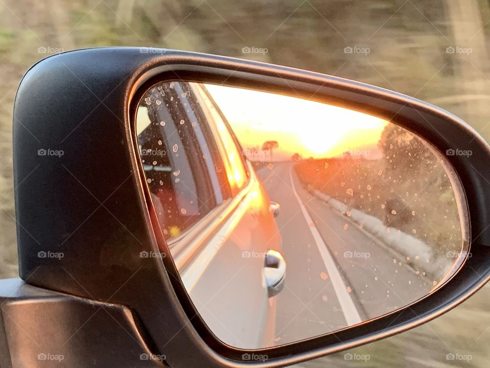 Reflection of the sunset by the car mirror