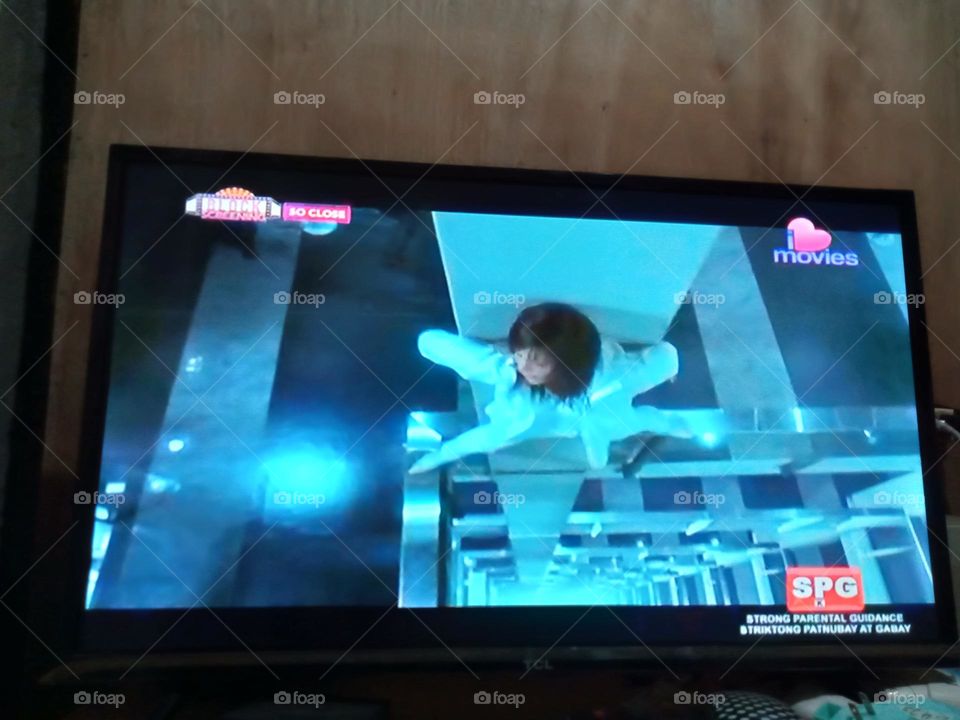 A SCENE FROM THE MOVIE,, SO CLOSE,, WHERE THE LEADING LADY IS HIDING WITH SPREAD LEGS FROM ENEMIES, AGAINST A BUILDING POST