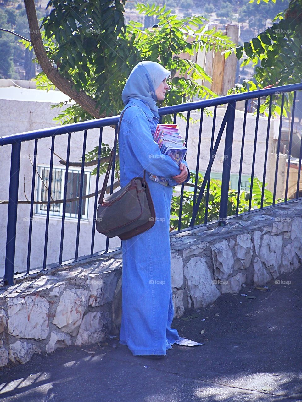 Woman waiting for bus en route to college in Palestinian quarter of Jerusalem, Israel 