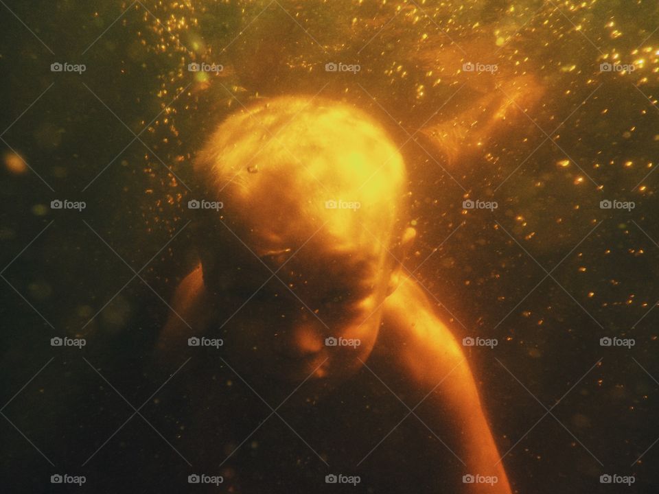 Boy diving underwater in the lake