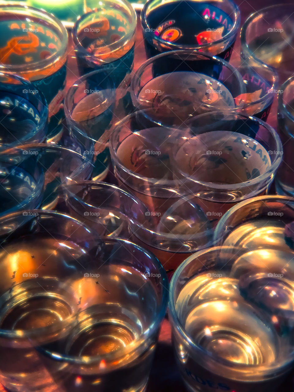 Lots of shot glasses viewed from above and to one side through a kaleidoscope lens