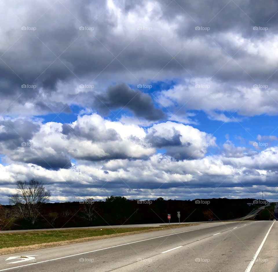 Waves of autumn clouds over empty highway