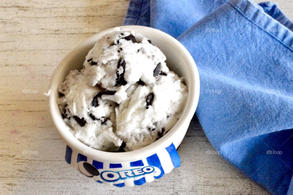 Oreo cookie ice cream flat lay on a white rustic background with a blue towel 