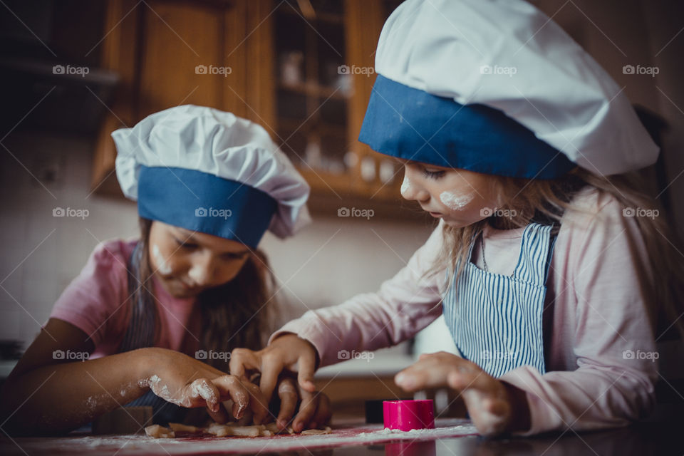 Little sisters cooking the biscuits 