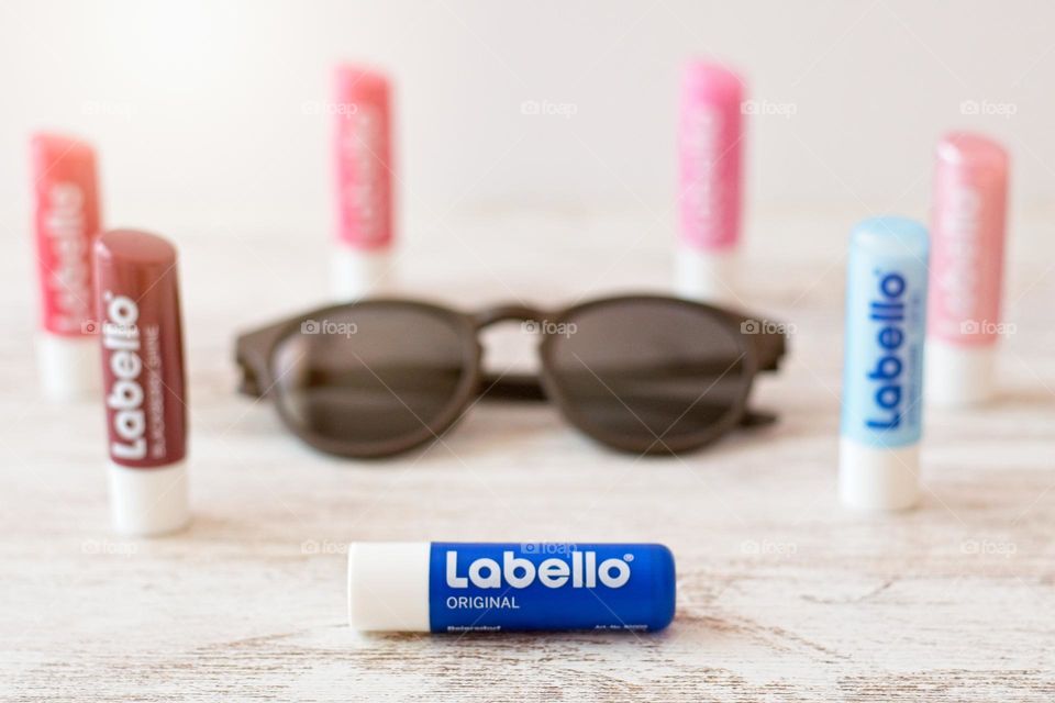 Labello lipsticks in a circle around a pair of sunglasses 