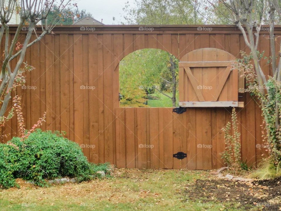 a wooden fence with a cutout window to expand the view