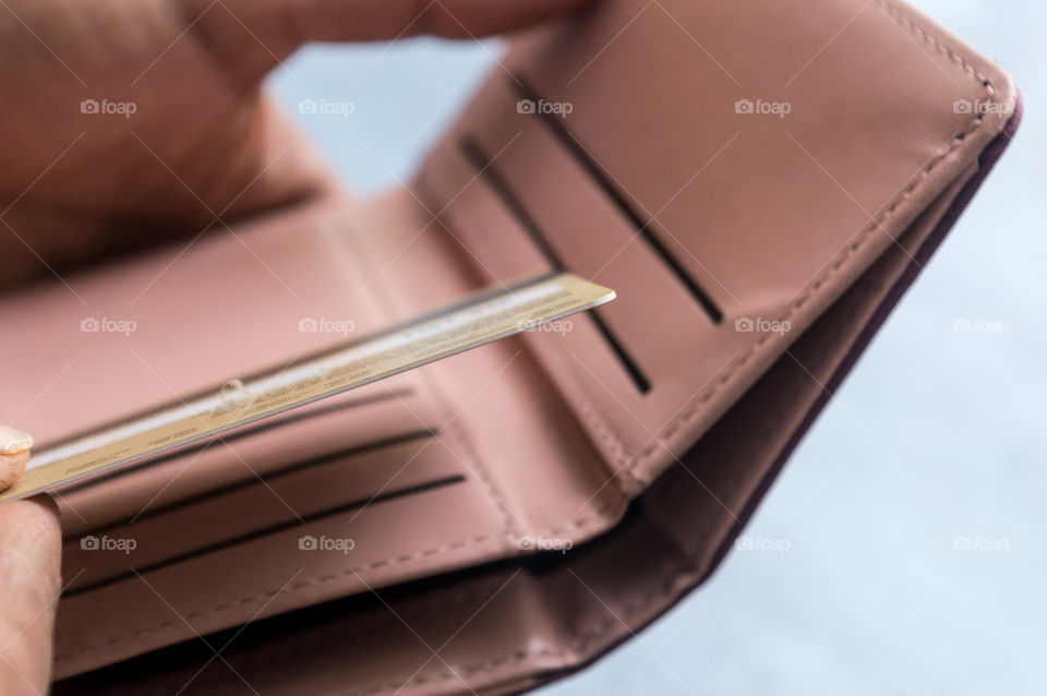 Closeup photo of young Businessman putting or taking out or paying with credit card in leather wallet on white background. Selective focus. Earning crisis growth bribe corruption bankrupt concept.