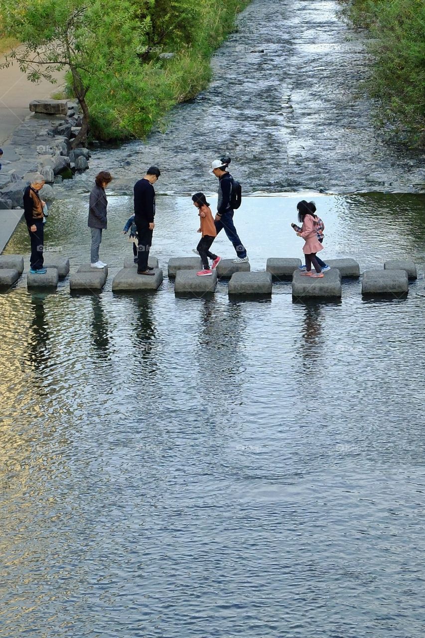 A family crossing the stream