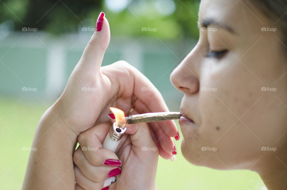 Woman lighting up a cannabis joint