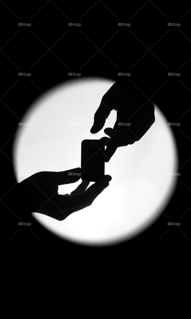 Silhouette of hands holding a box