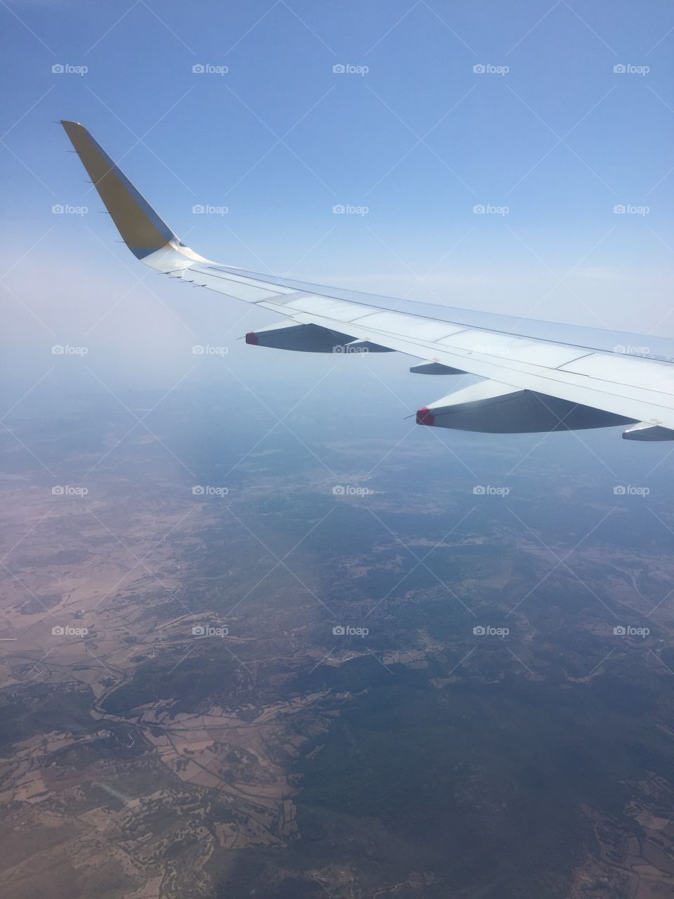 I’m on top of the world ayyye.. sun reflecting off wings on plane. Spain sits 6000 feet below, on way to. Whole new world 