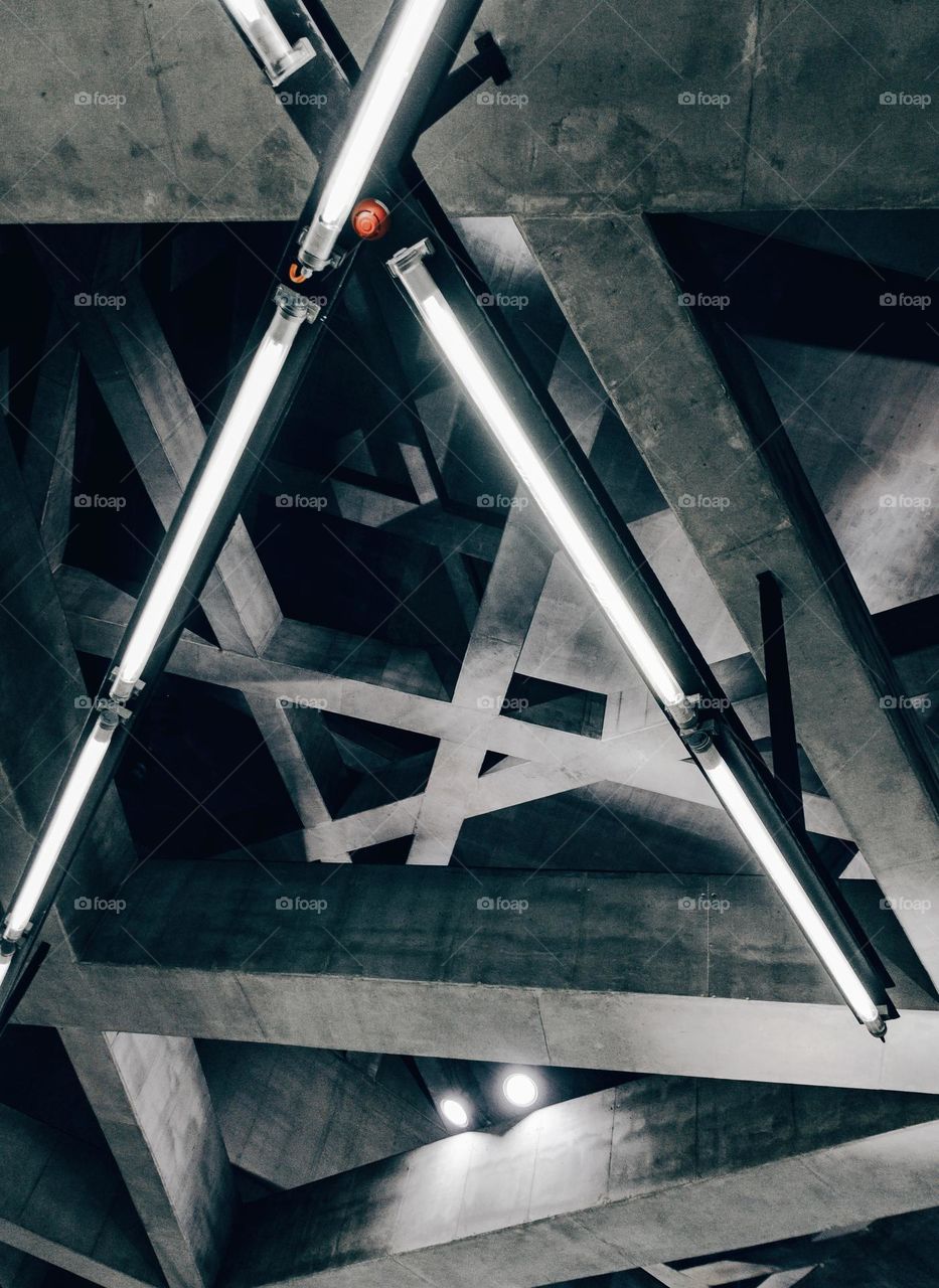 Building interior with concrete beams forming triangular shapes