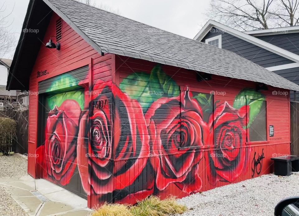 Floral graffiti of red roses painted on a garage in Flower Alley by #muckrock