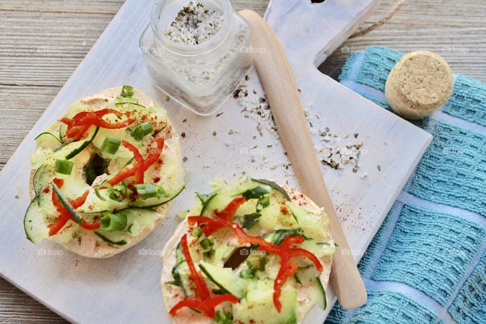 Salmon spread with thinly sliced cucumber, red pepper, and green onion on toasted bagel 🥯