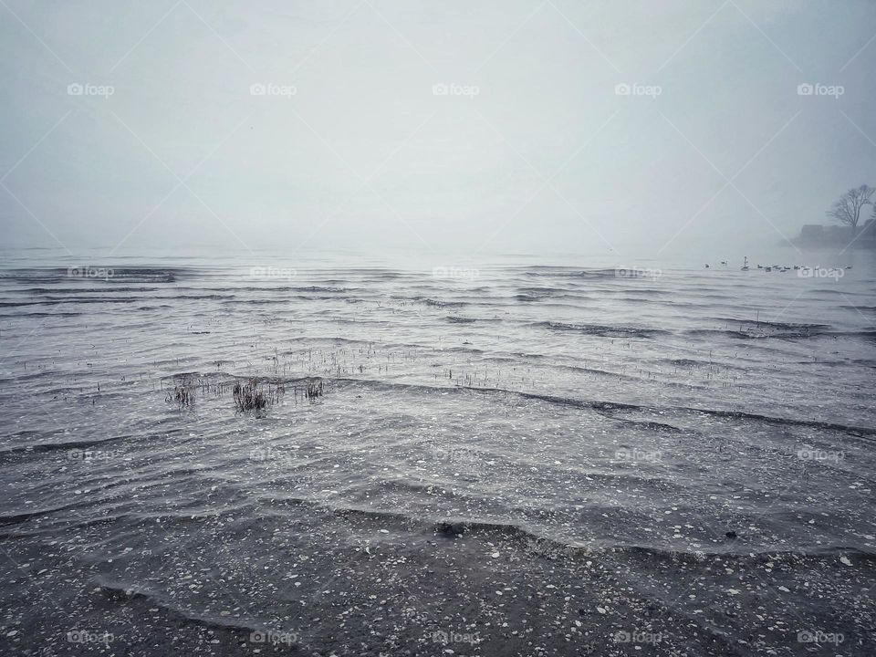 Tide coming in on a foggy beach 