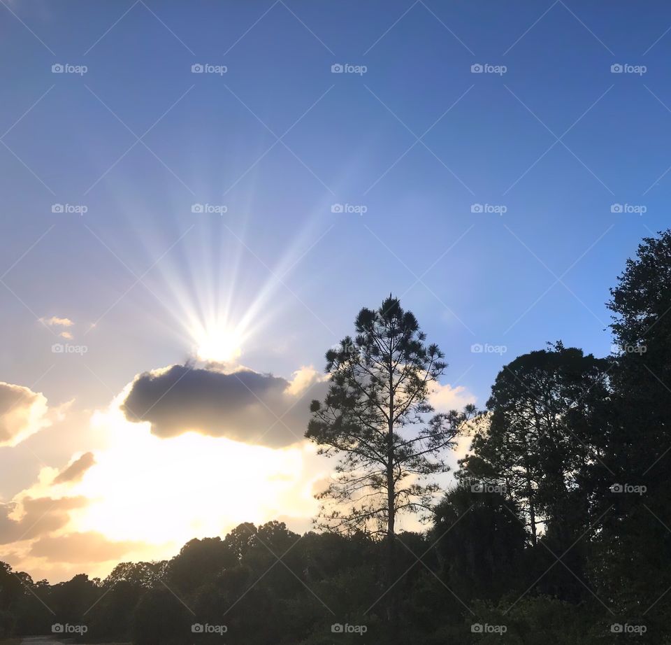 Sun rays bursting from the clouds at sunset.
 