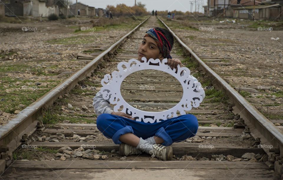 A child on the railroad tracks wiht mirror!