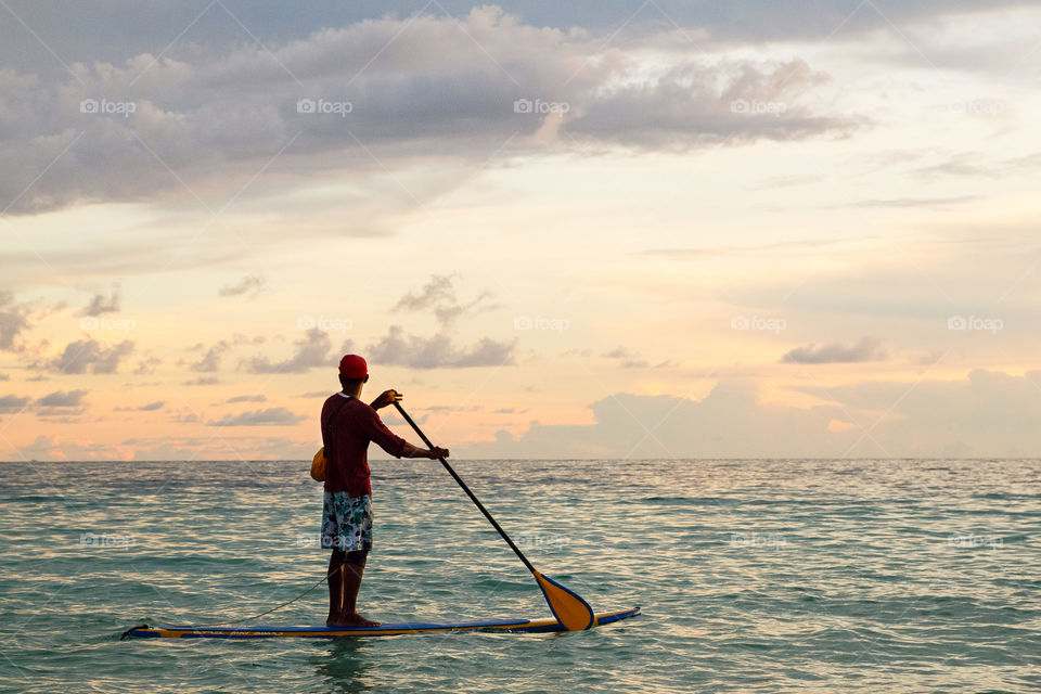 Men using stand up and puddle board on the sea