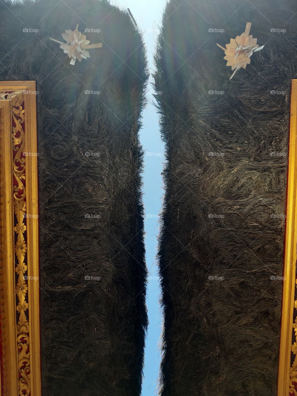 The blu sky act as a separation between two palm fiber roofs