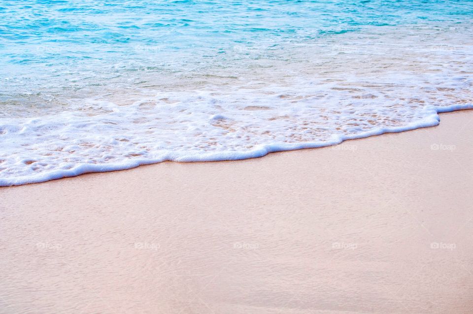 Clear beautiful waves roll over the white sand beach of Grand Turk. 