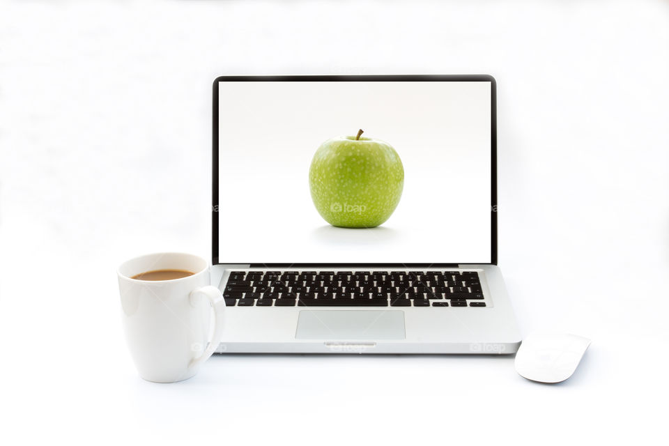 A laptop computer on an isolated white background with an apple screen saver. MacBook and hot cup of coffee.