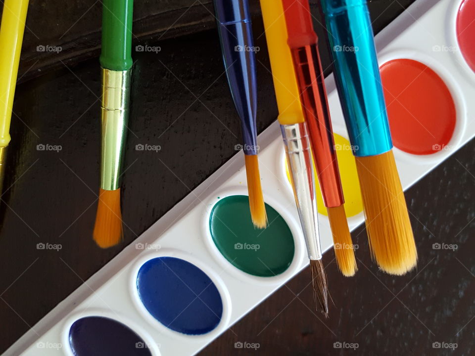 Palette of watercolor paints with a paintbrush