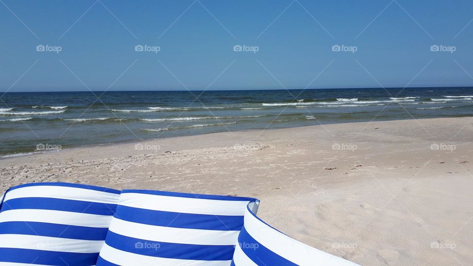 the beach on sea shore in summer with screen in stripes white and blue cereleum colour