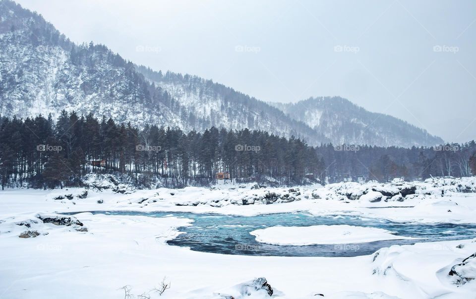 White whiteness with turquoise river and majestic snowy mountains.