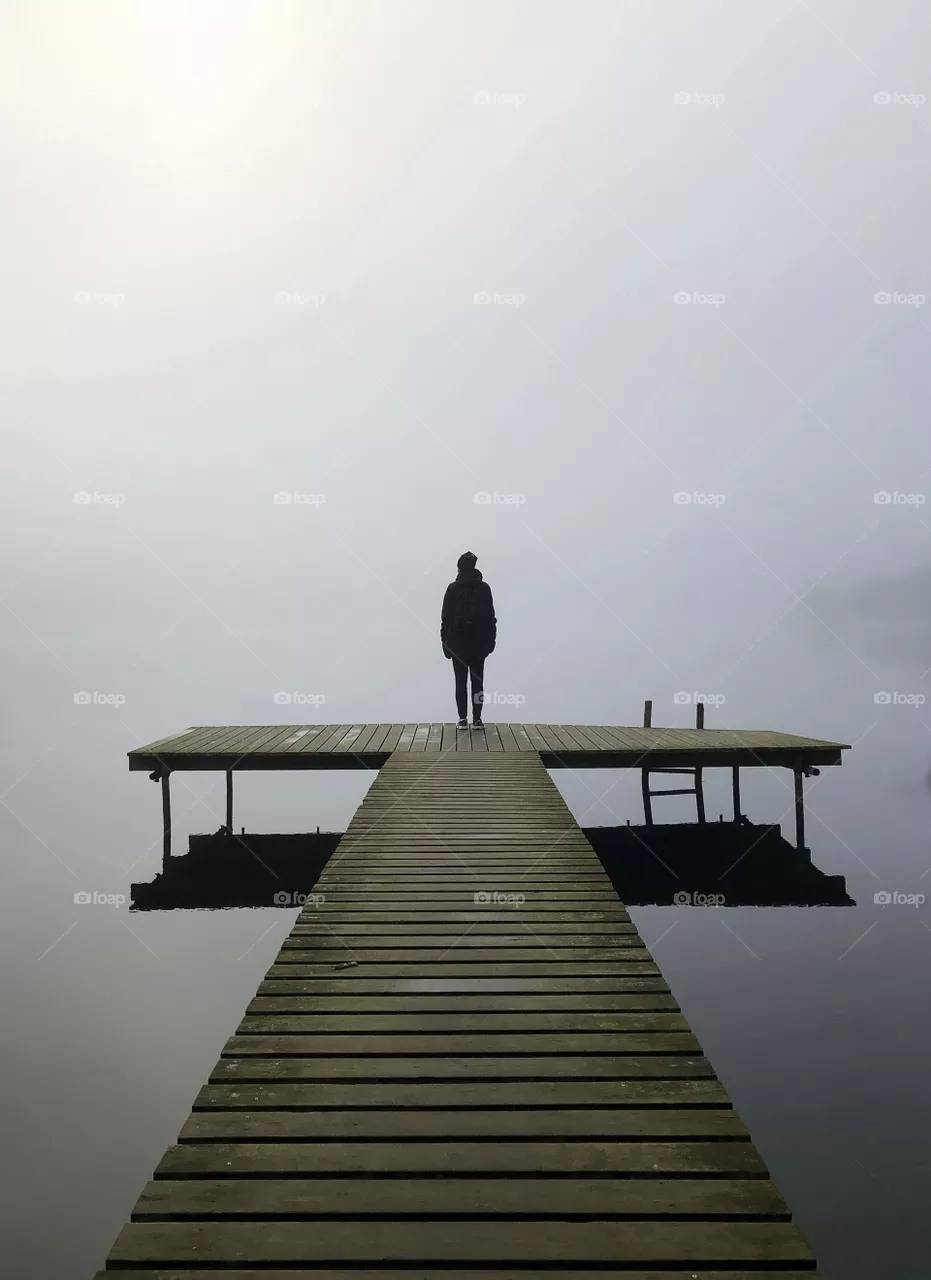 Standing alone in the fog, by the lake