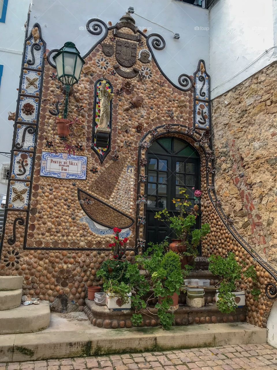 Beautiful facade of a residence in Algarve; painstakingly made of pebbles & shells of various shapes & sizes ...