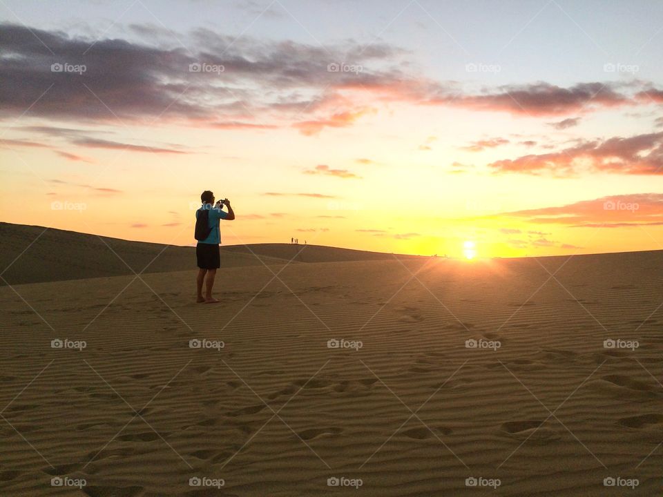 Person taking photographs during sunset