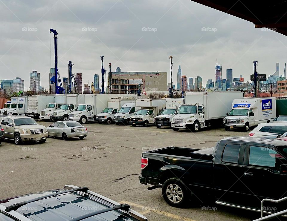 This is the parking lot of „ACCESS Storage“ on „Review Ave“ near „Borden Ave“, the BQE and „Dutch Kills“. They get many deliveries as well as people tending to their lockers in need to rent trucks parked here ready to go. 2023. Hypnotic Productions