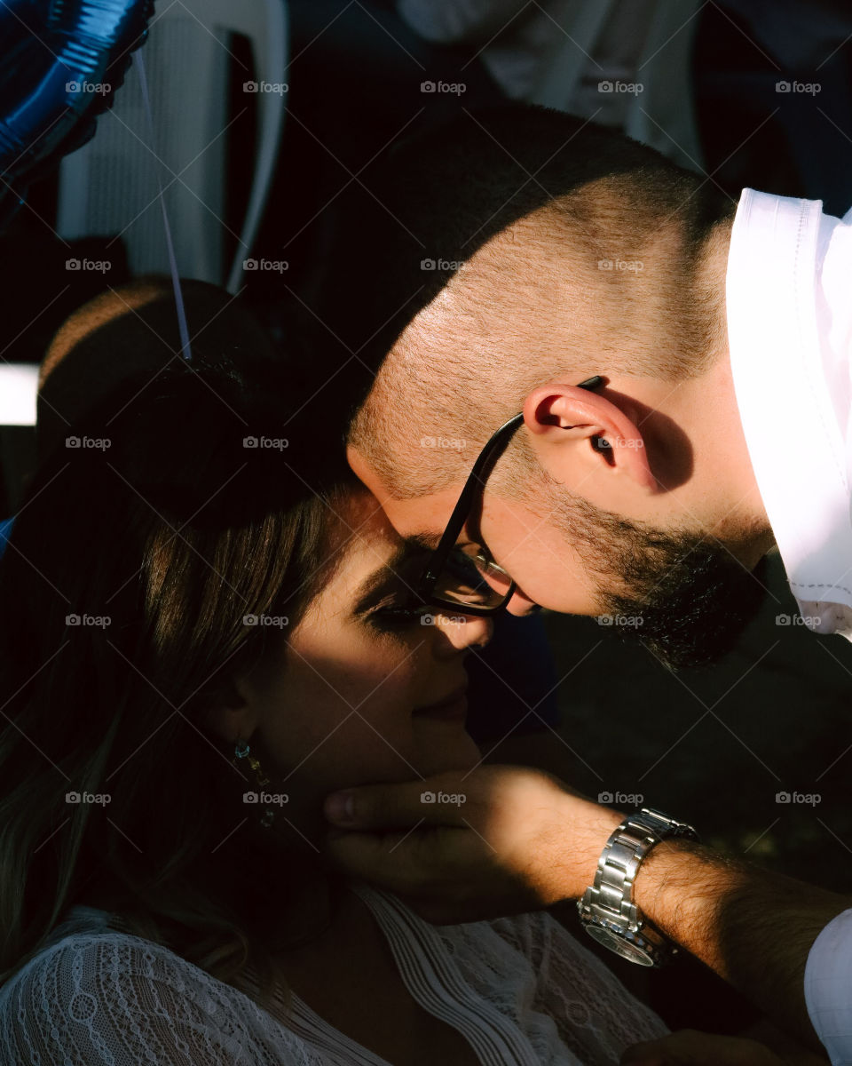 a couple look at each other at theirs baby's baby shower, Love captured in a picture.
