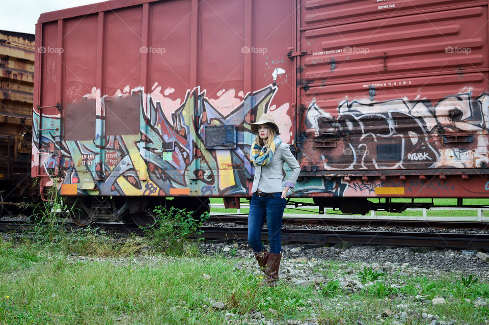 Woman standing in front of a colorful train car in a field
