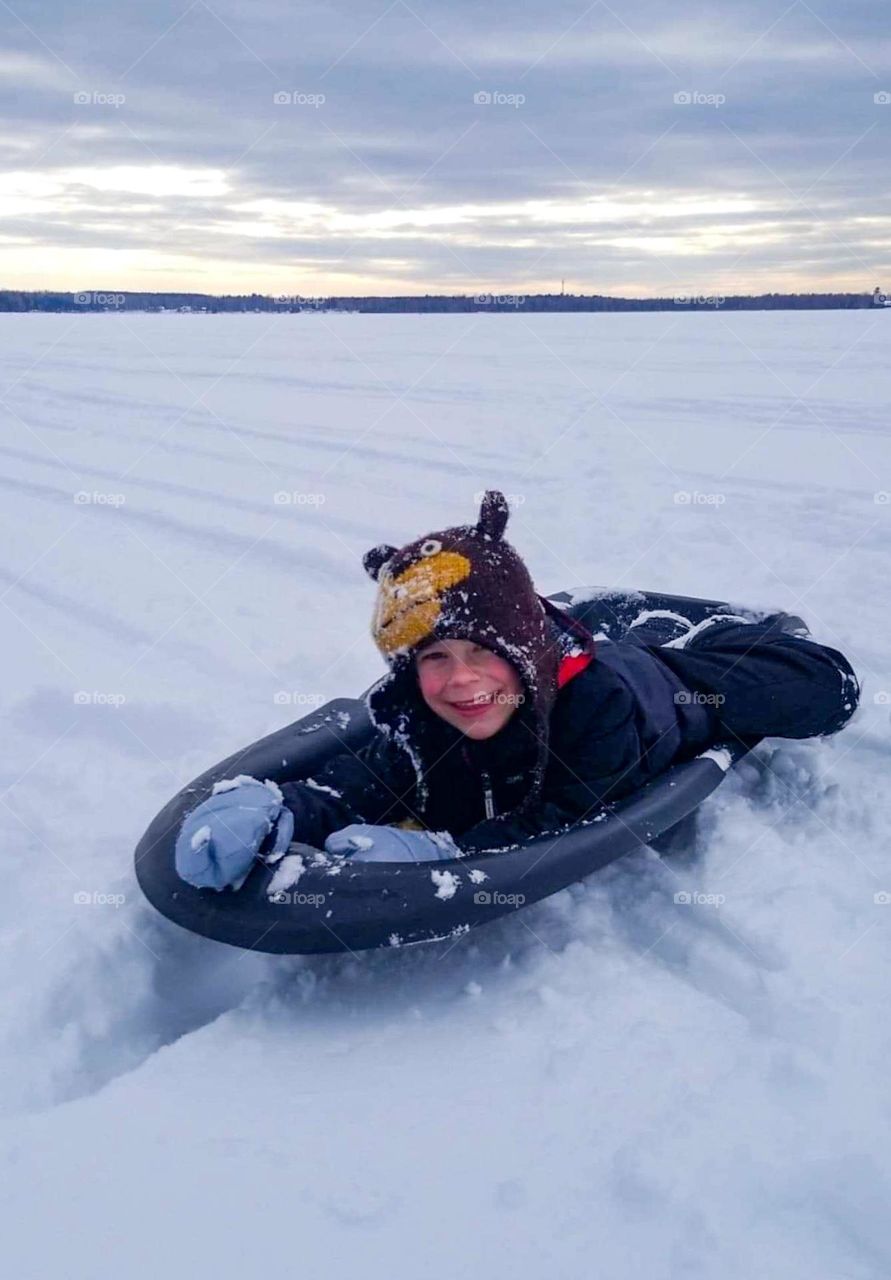 Boy on sled in the snow