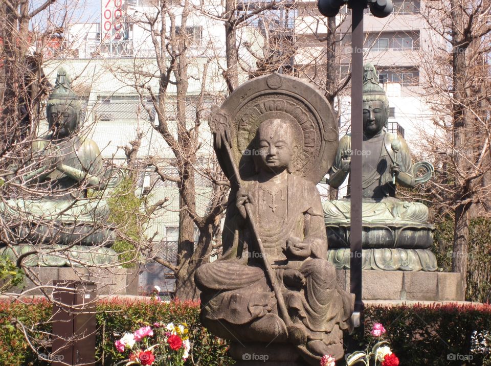 Stone Buddha Statues Among Trees. Asakusa Kannon. Sensoji Buddhist Temple and Gardens. Tokyo, Japan.