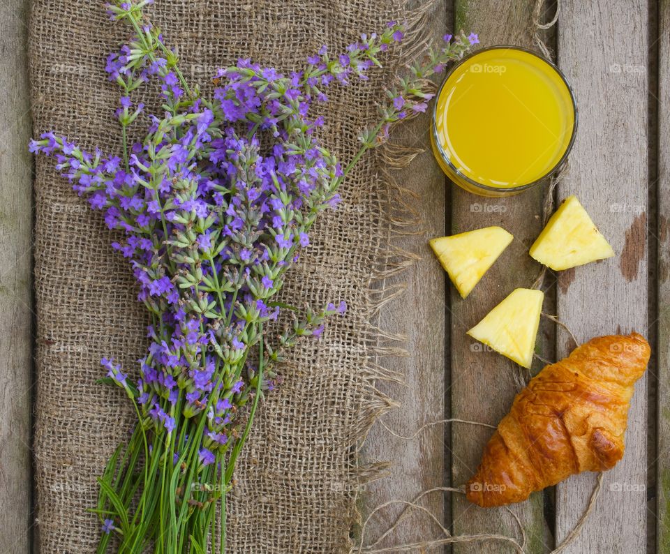 Bunch of lavender flowers and a summer breakfast on a wooden surface. Flat lay.