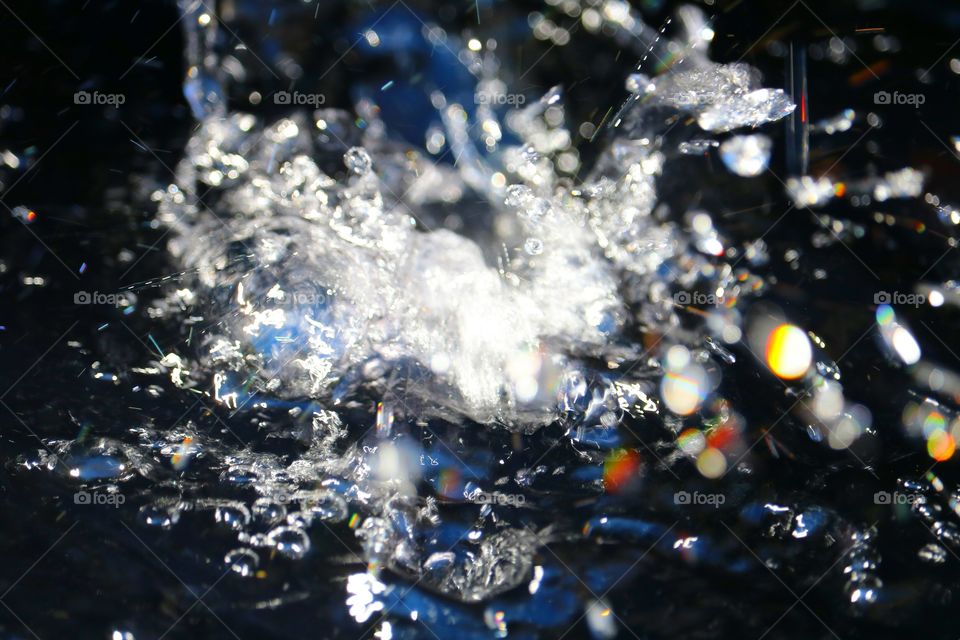 light reflecting on water falling from fountain