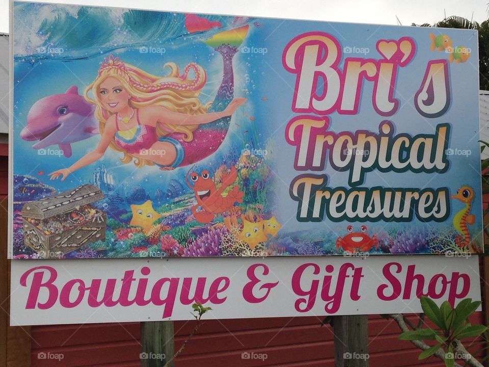 Bri's Tropical Treasures Boutique & Gift Shop billboard sign with mermaid