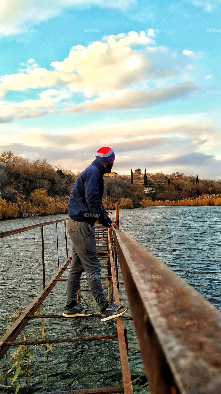 man on a beidge by the lake