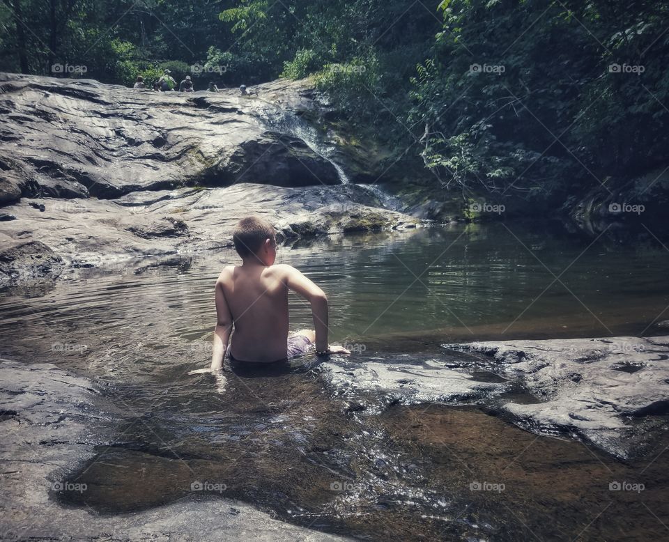 Boy Bathing in Natural Pool