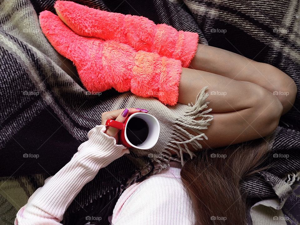 Drinking coffee in pink sweater in cozy bed 