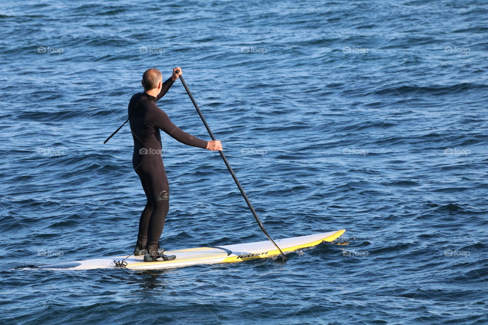 Solo paddle boarding on calm ocean 